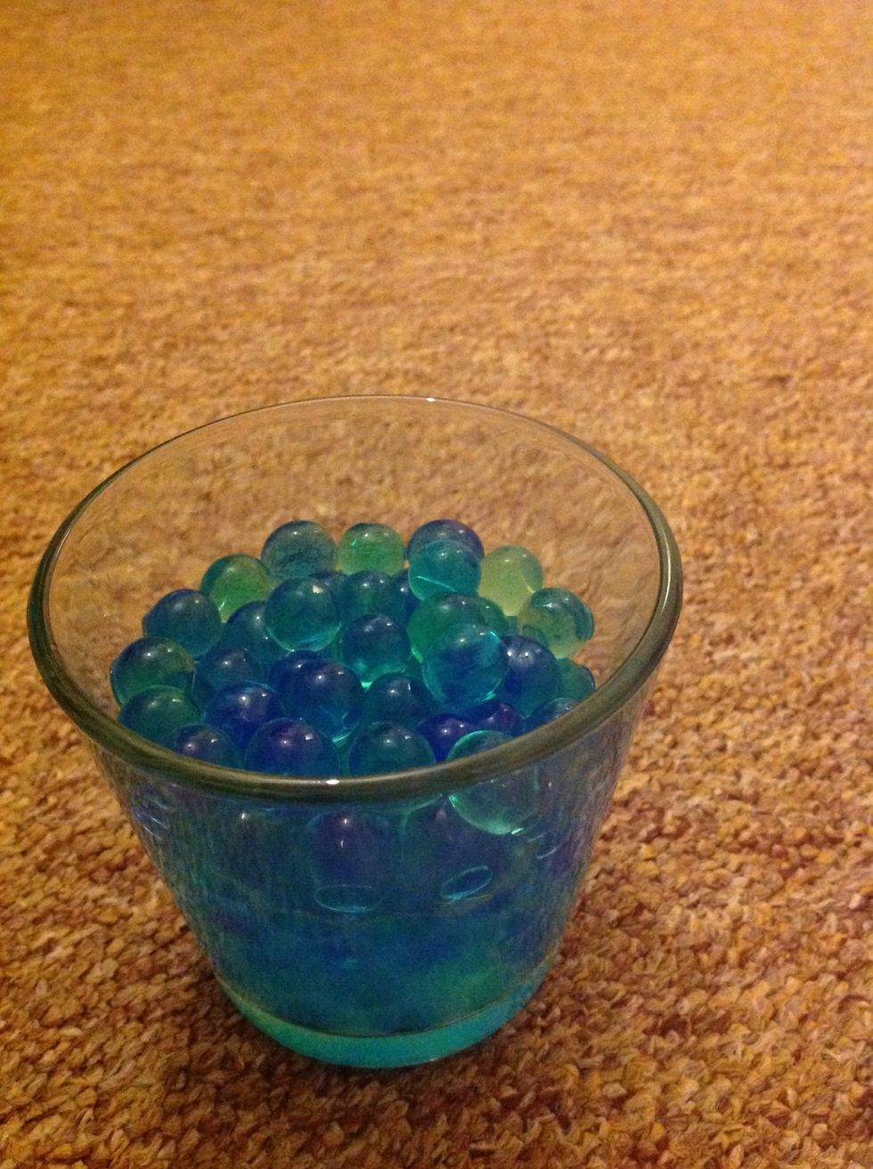 Arrange your beads in the colours that you want into your container and fill it halfway through with your fragranced water from the bead growing bowl. As a finishing touch add a drizzle of extra oil.