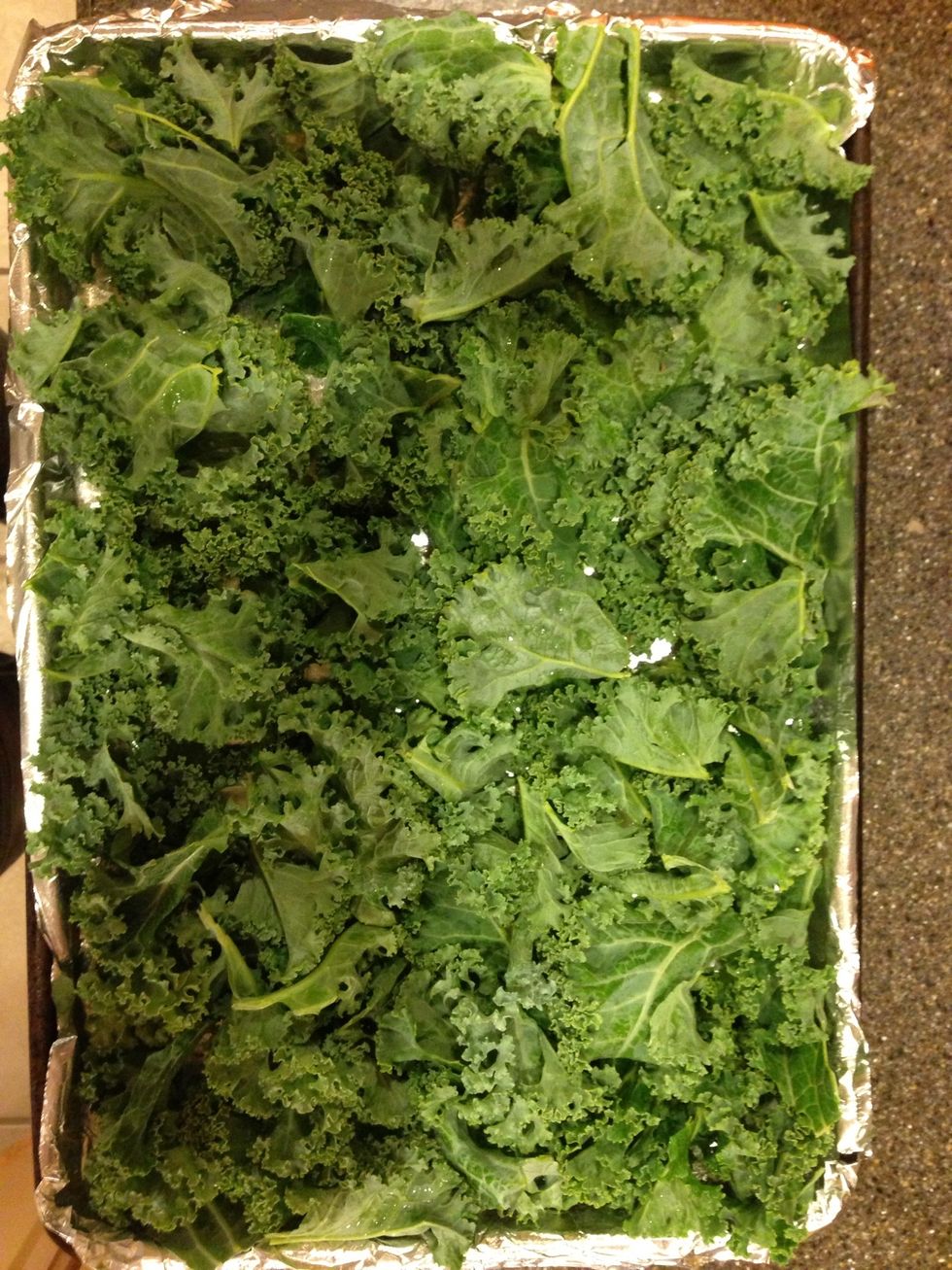 Arrange your kale on the baking sheet. Give that sucker some salt, pepper & any other seasoning you want ( I used cayenne pepper for this batch!). Lightly spray it with olive oil again.