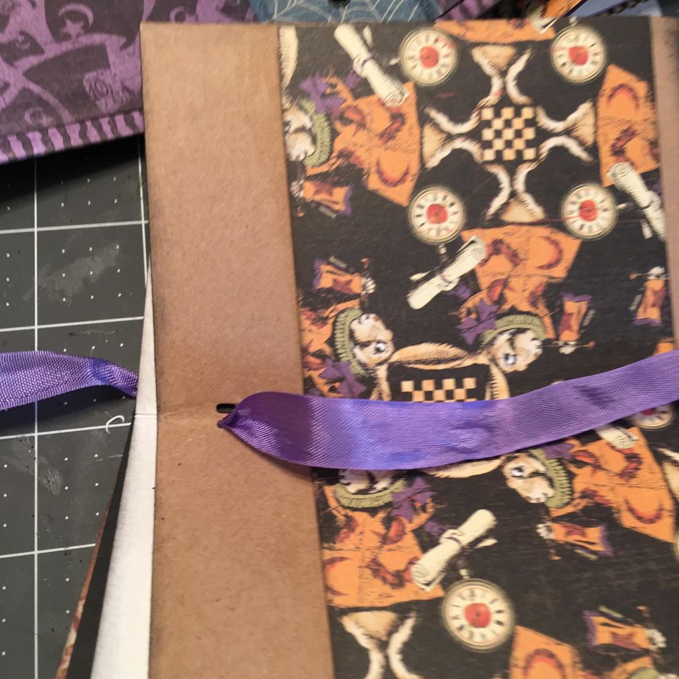 Arrange your pages into 3 signature sets, adding as many pages and envelopes in different sizes as you like.  Thread ribbon from the inside through the holes and out to the outside spine area.