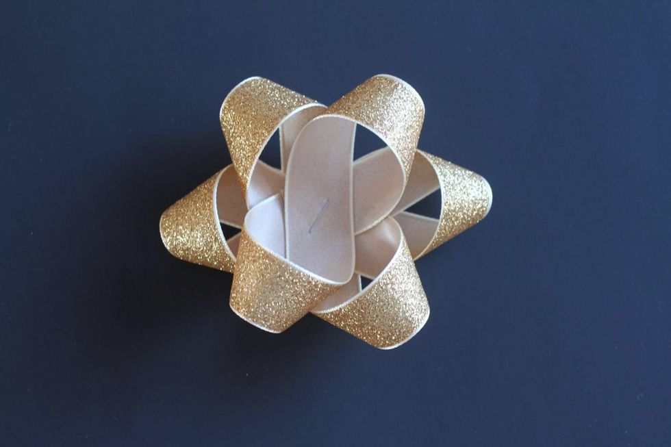 Arrange your three large figure 8\u2019s on top of each other with a dot of glue between each one.