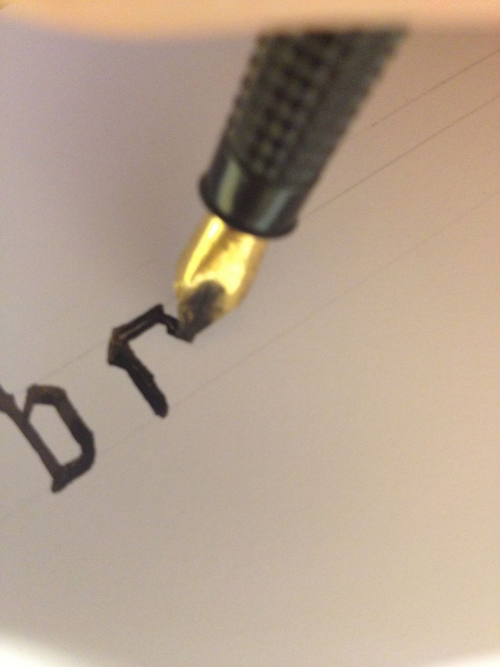 As an added flourish, you can add a small "tail" to the end of this stroke; rotate your nib to roughly 90 degrees and make a thin curve downward.