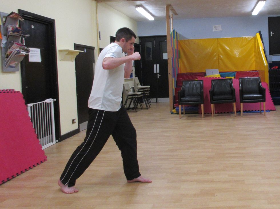 As I prepare to launch the punch, my weight is rooted to the front foot. My head is covered with the other hand to block. I pivot the rear foot to turn the hips. I avoid winging the punch.