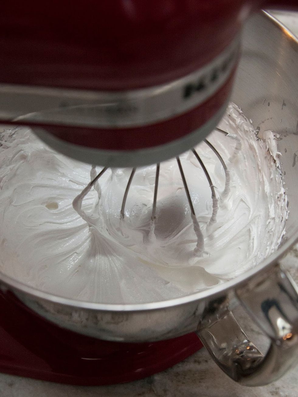 As soon as the egg whites and sugar reach 115, take your bowl or your stand mixer bowl and using a beater with a whisk attachment at high speed, start whipping the stuff up.