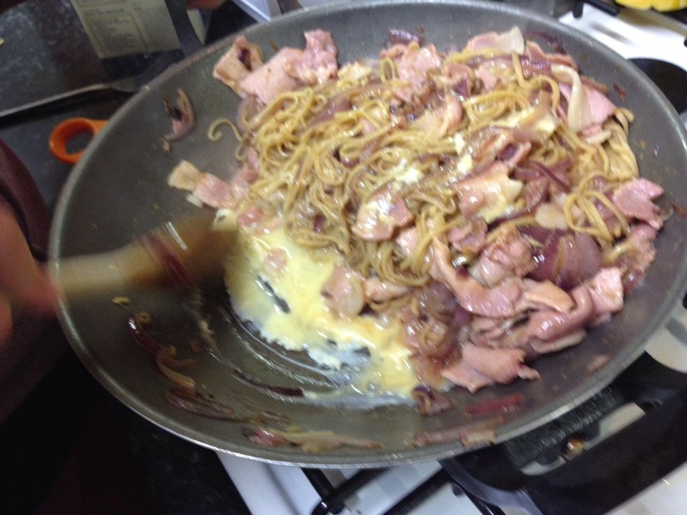 As the egg begins to cook and turn white around the edges take a spoon (we used wooden) and slowly push it into the noodles.
