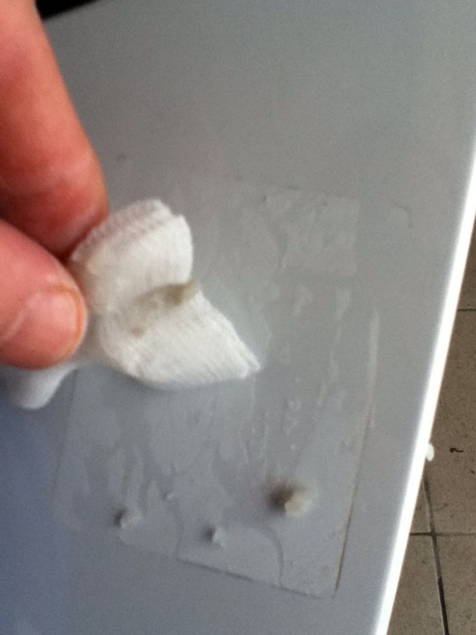 As the glue dissolves, apply more pressure. Use circular motions to avoid scratches.