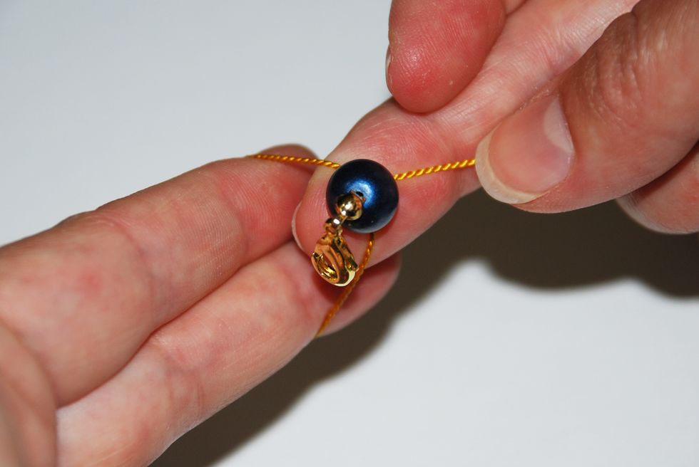 As the loop is sliding off your fingers, push your stone inside the loop.