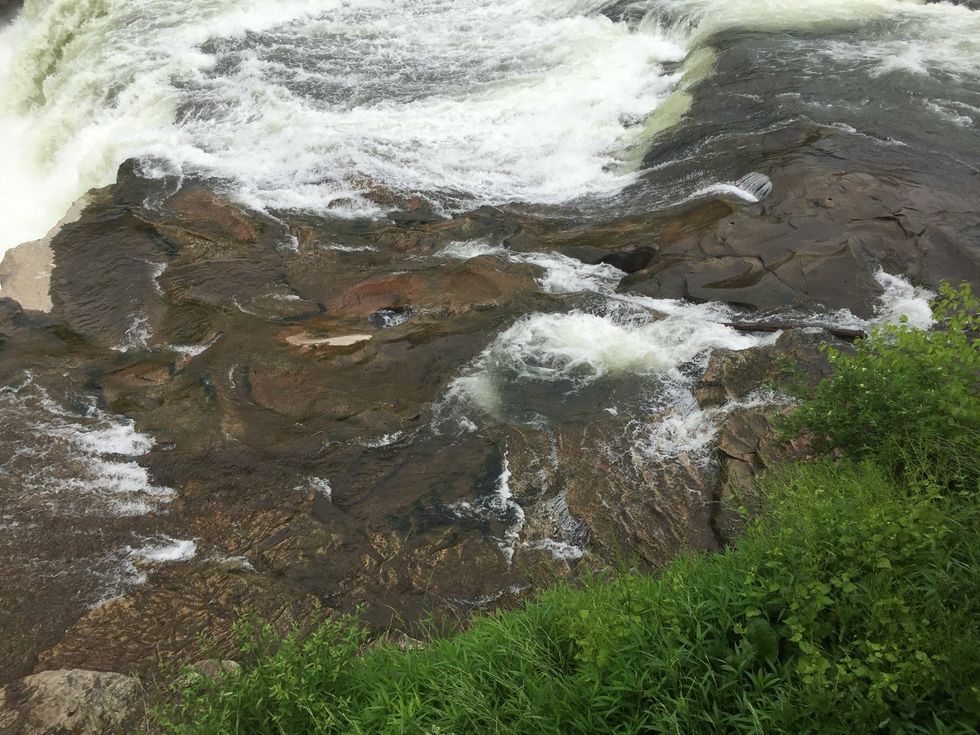 As the water goes over the rock year after year it shapes the rock making it have ridges and holes taking the smaller particles down the river (erosion)