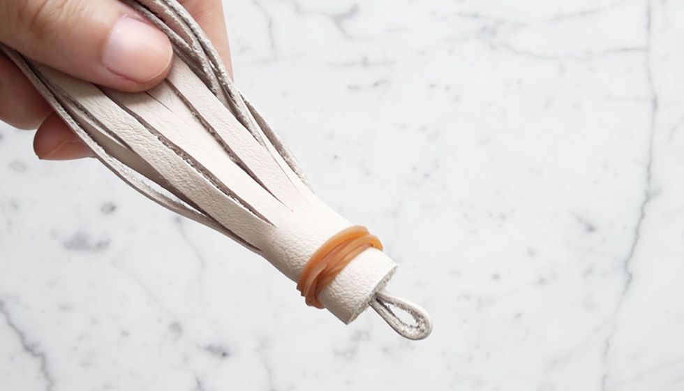 As you approach the end, add a small dab of glue and wrap over. Tie a rubber band around the top of the tassel to help keep it all in place until the glue is completely dried.