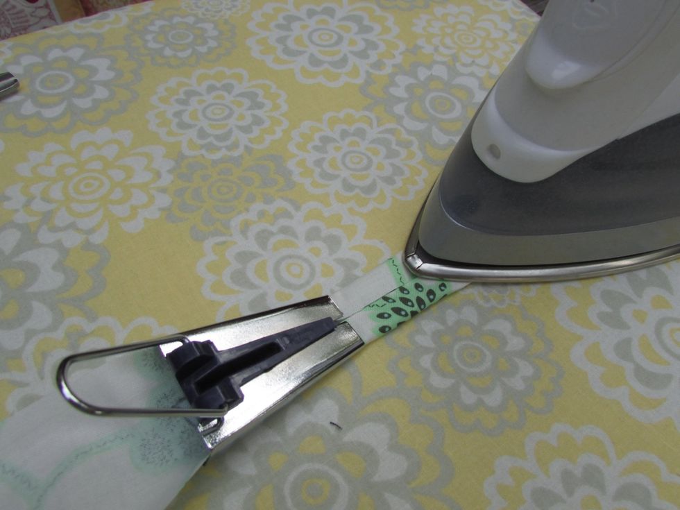 As you gently pull on the bias tool, use your steam iron to press your new trim flat.