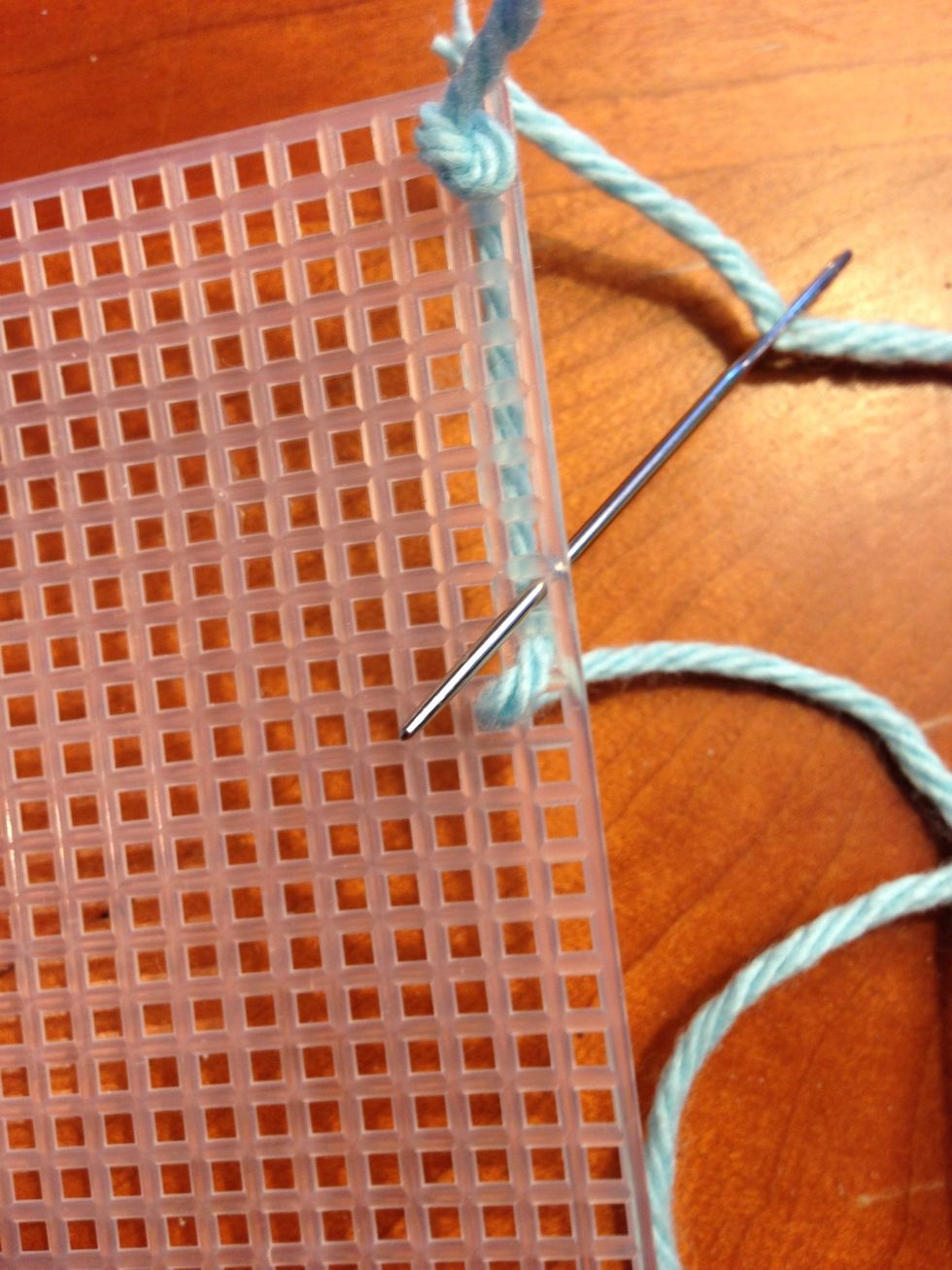 As you push the needle back through the canvas, stitch so that the straight length of yarn will be covered by your stitch, by keeping the straight length in the middle between the two rows of stitches