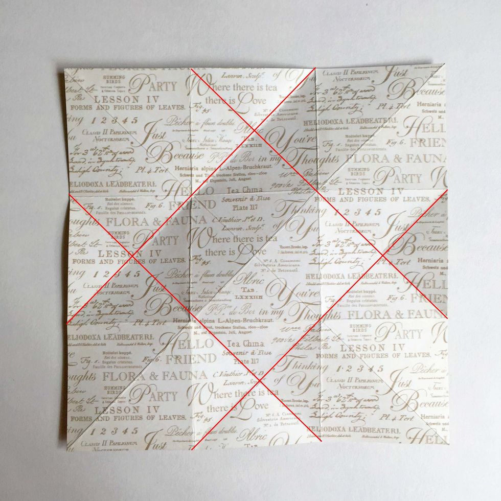 As you unfold the paper, you will get 4 diagonal folds across the paper as indicated by the red lines here...