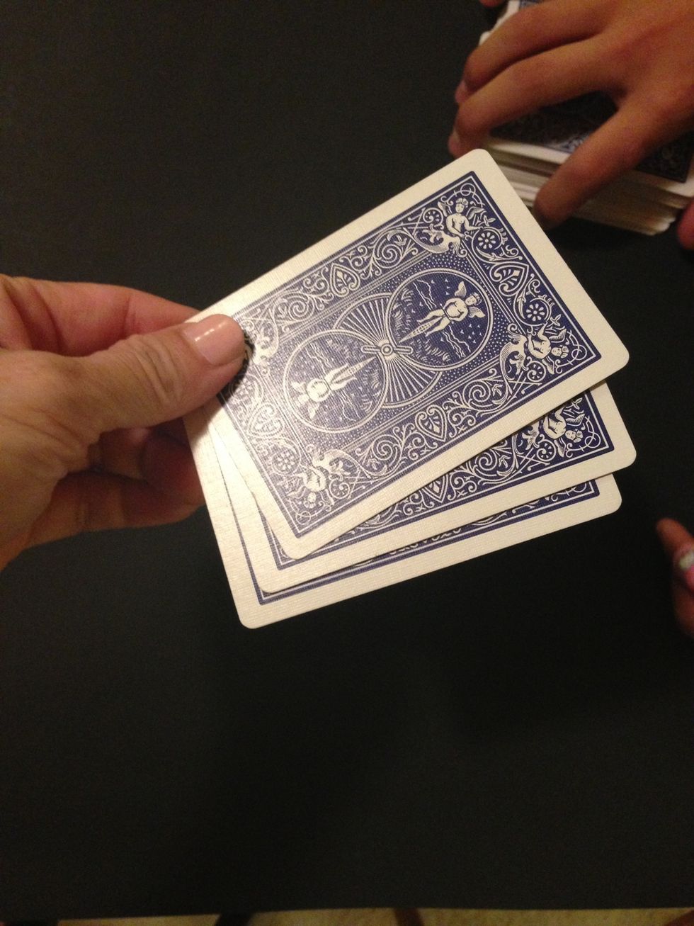 Ask them to hold the cards in the corners and make sure their card is on the bottom.