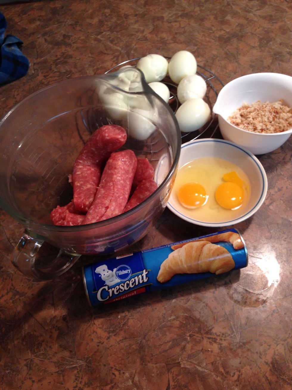 Assemble ingredients... 2 raw eggs, your peeled hard boiled eggs, sausage and bread crumbs.