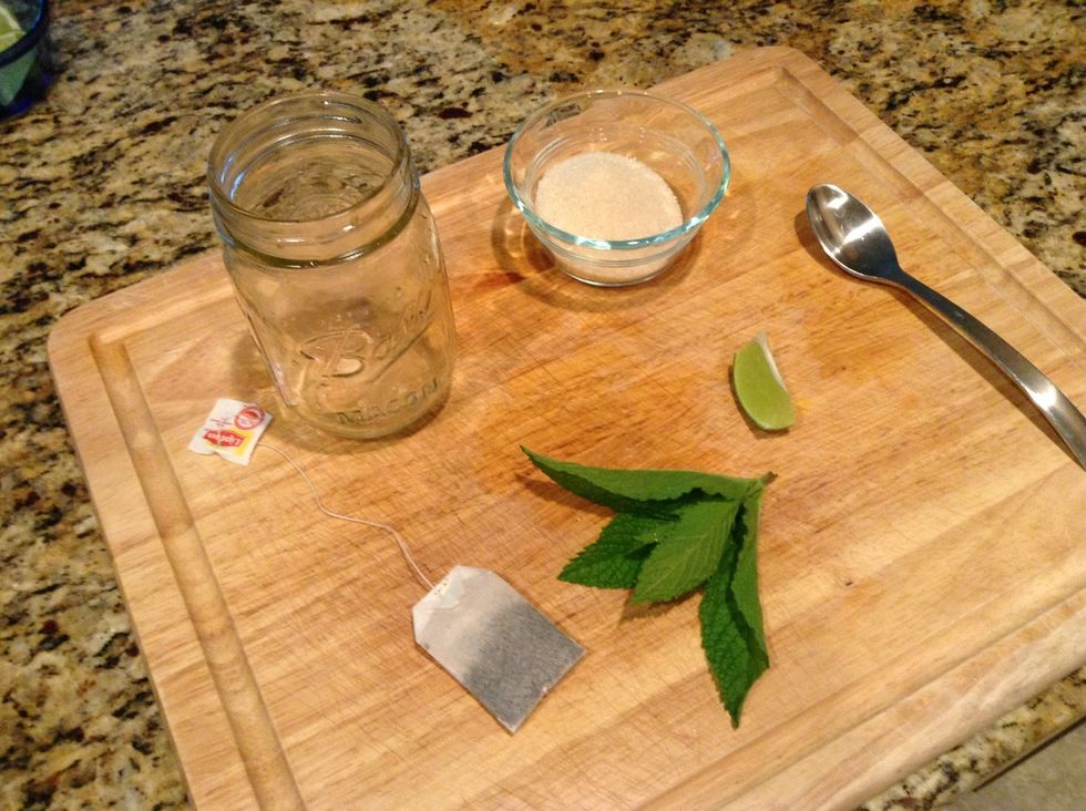 Assemble the ingredients... Sugar, lime, mint sprig and tea bag.