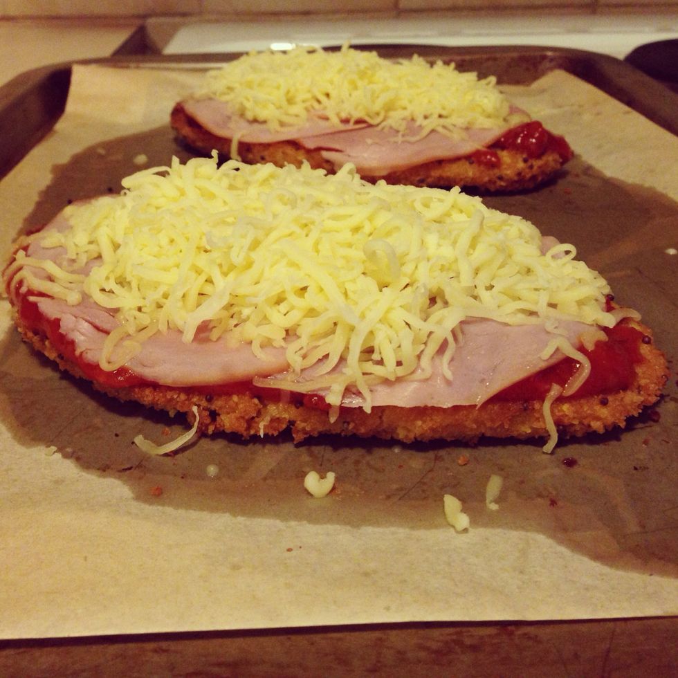 At 20 minutes, take schnitzels out of the oven and add sauce, ham then cheese. It's important to add toppings in that order for the best Parma! Put them back in the oven till cheese has melted.
