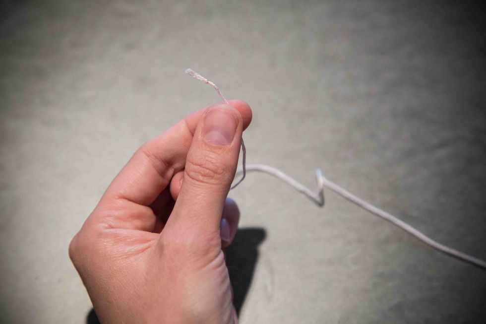 At the opposite end of the embroidery floss, tie a single knot.