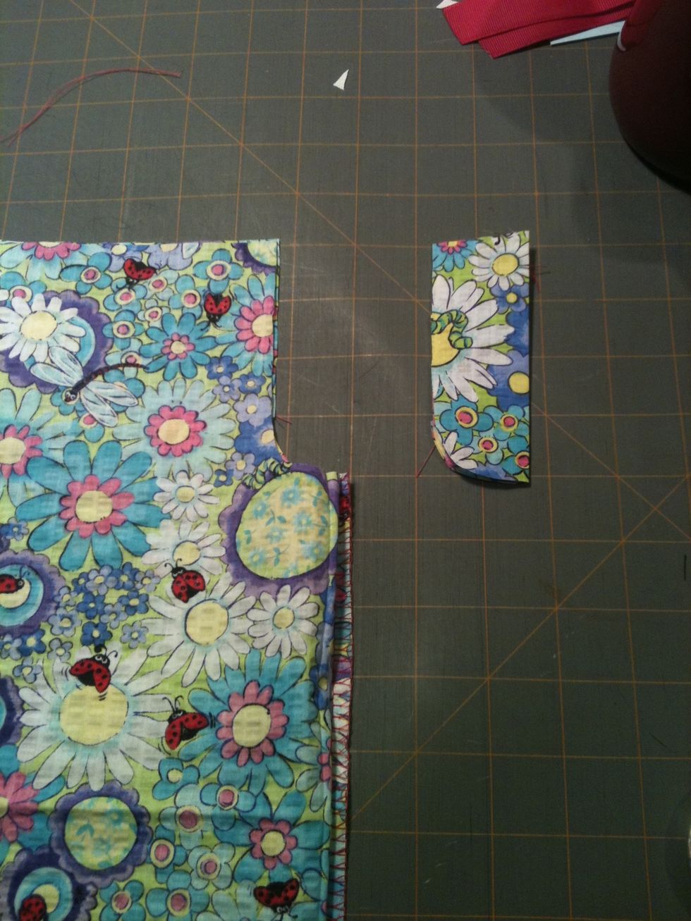 At the top right corner, cut a notch for the armholes, about 1x4 inches. Exact measurement isn't important. Cut through all four layers so your armholes are even and symmetrical.....