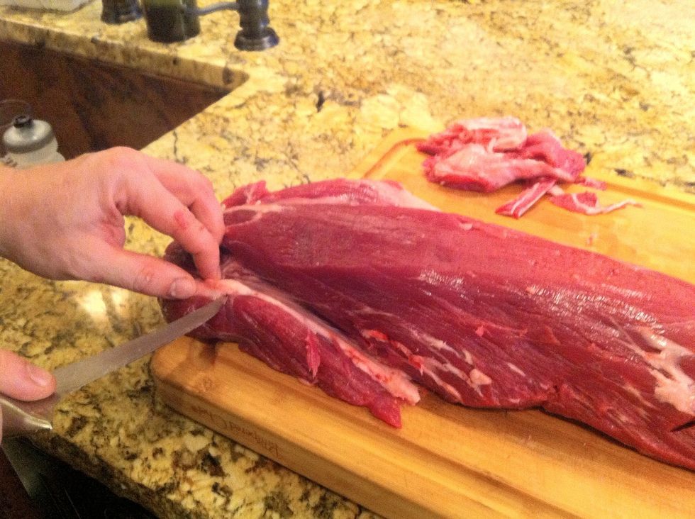 At the wide end of the loin there are three muscles that come together, and membranes that connect the three.  Pull the smaller muscle towards you, exposing the membrane.