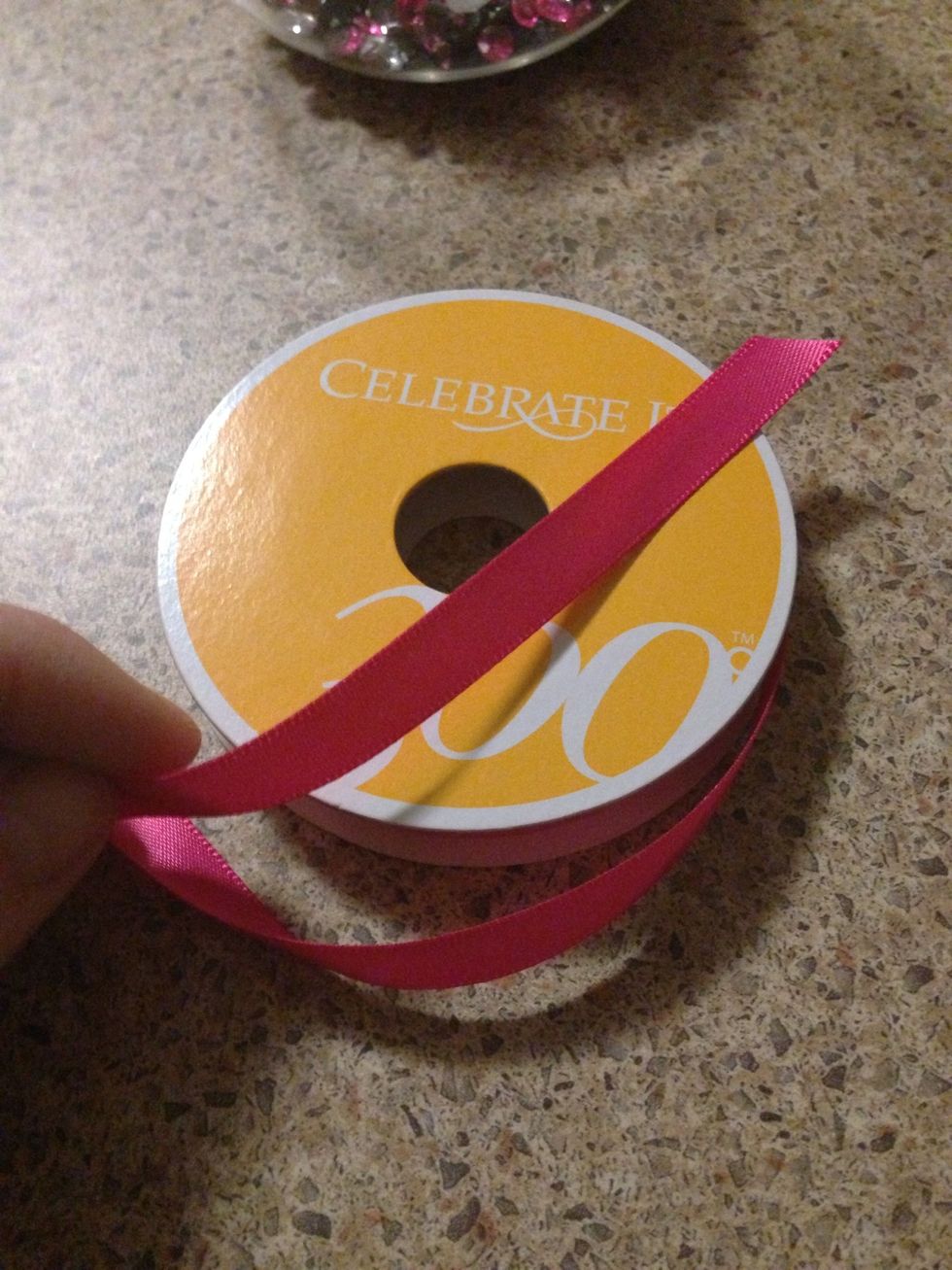 At this point plug in your glue gun and get it hot. Grab your ribbon and measure it around your container so that the ends overlap slightly, then snip off the ribbon from the roll.