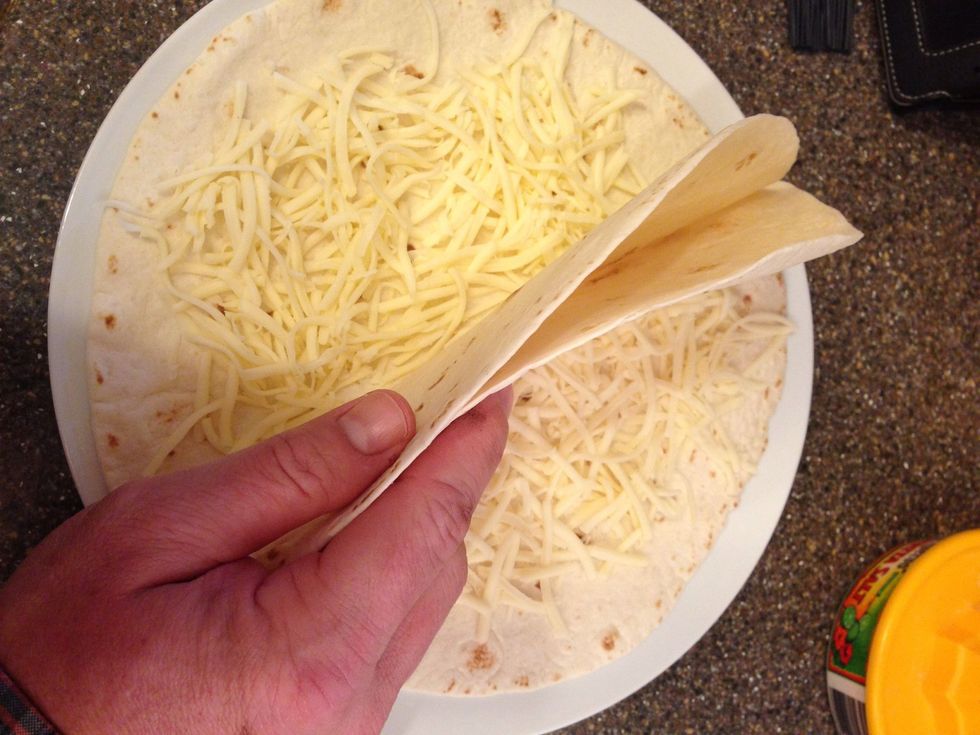 At this point start building your quesadillas putting cheese in the tortillas. I've done it both ways - full and half quesadillas. Half is MUCH easier to deal with on a grill.