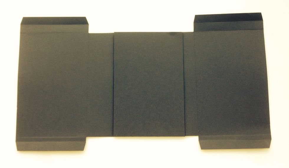 Attach 1/2" tabs  of score sections to back of 4" x 6" rectangle. Make sure the wider vertical spine is on the left side. The 1/2" horizontal spines should be to the top.