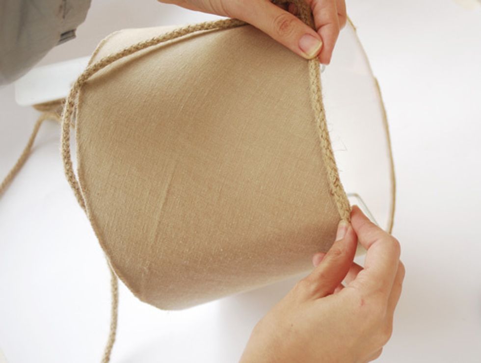 Attach a Jute rope to the edge of the lampshade with hot glue or fabric adhesive