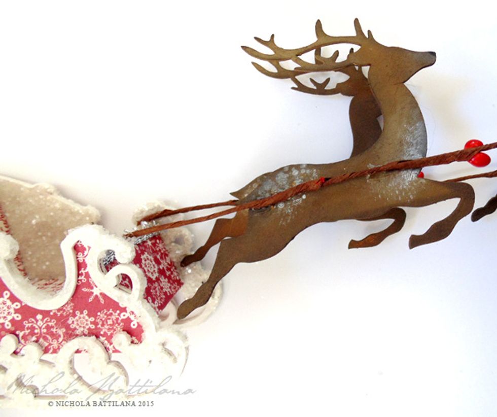 Attach a length of wired Red Pip Berry Garland to the sleigh, then glue the deer on to the wire.