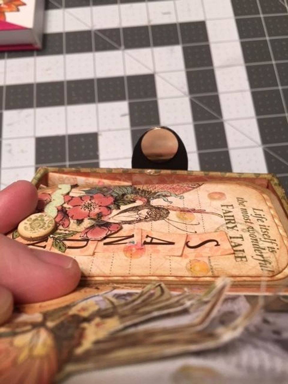 Attach an opposing magnet paper snap to the back of the keyhole as shown in this photo. Do not cover the magnets with paper. You want them exposed so they can slide apart when  you open your box.