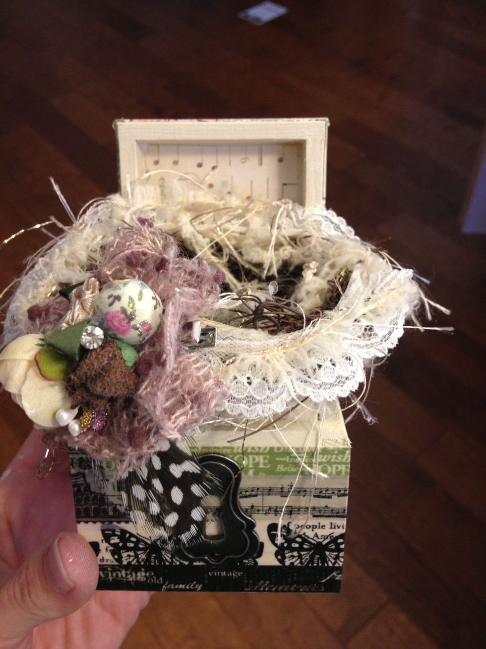 Attach the bird nest to the inside of the box. Put some glue on the inside of the lid too, so that the lid remains open.