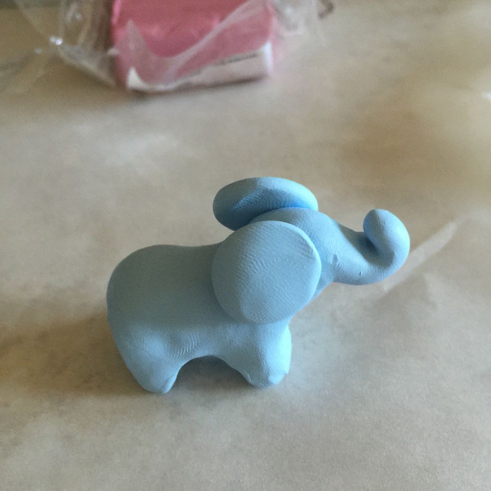 Attach the disks to the side of the elephant's face.