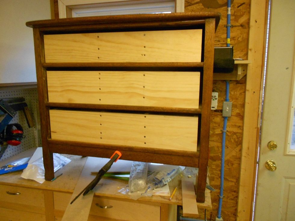 Attach the drawer slides following the manufactures directions. Attach the drawer fronts from the bottom drawer up using clamps to hold them in place and screwing from the inside.