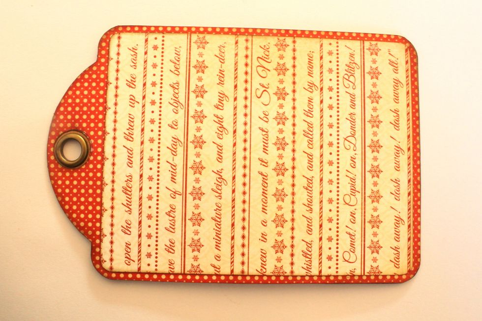 Attach the red paper tag to the tag base. Cut out a rectangle that is slightly smaller than the tag from another paper out of the 8x8 Pad. Ink the edges and attach it on top of the red paper.