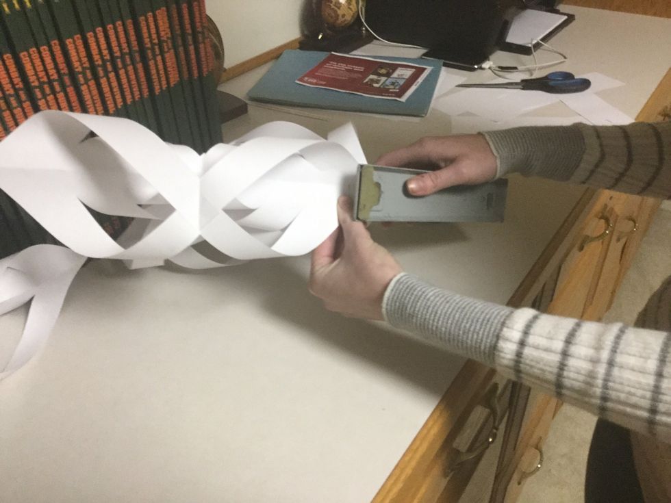 Attach the remaining pieces of paper to the bottoms of the the first two which are already stapled, and the middle section of the previously attached piece where one side hasn't been stapled yet.