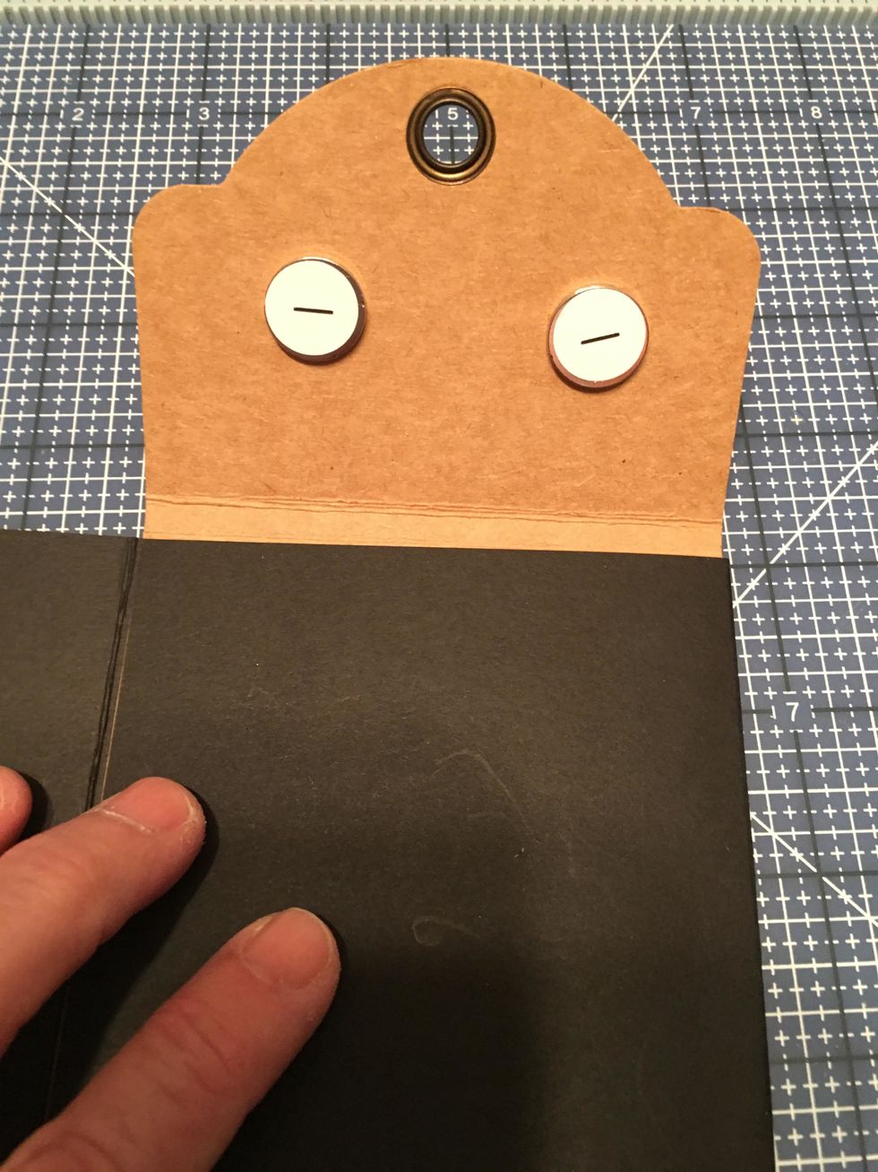 Attach the sticky side of the plus magnets to the inside of the flap as shown with the minus magnets and papers still attached.