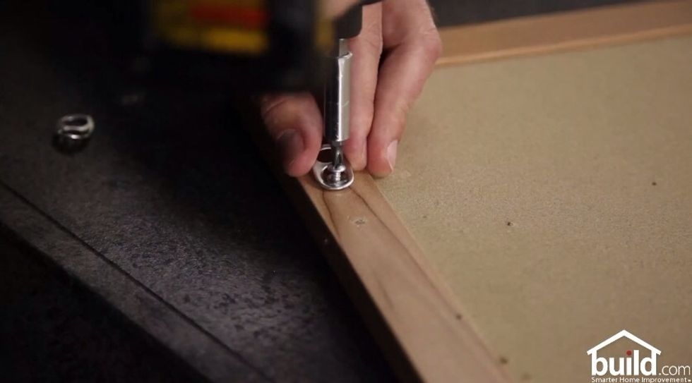 Attach the tab to your picture frame using a small screw.