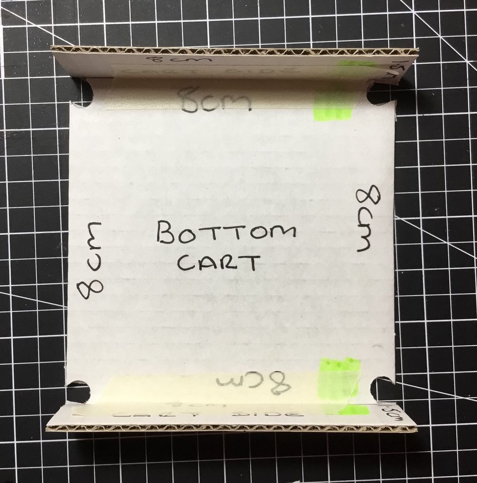 Attach with masking tape the pieces to the cart base that were marked with the pen in the earlier step as shown.
