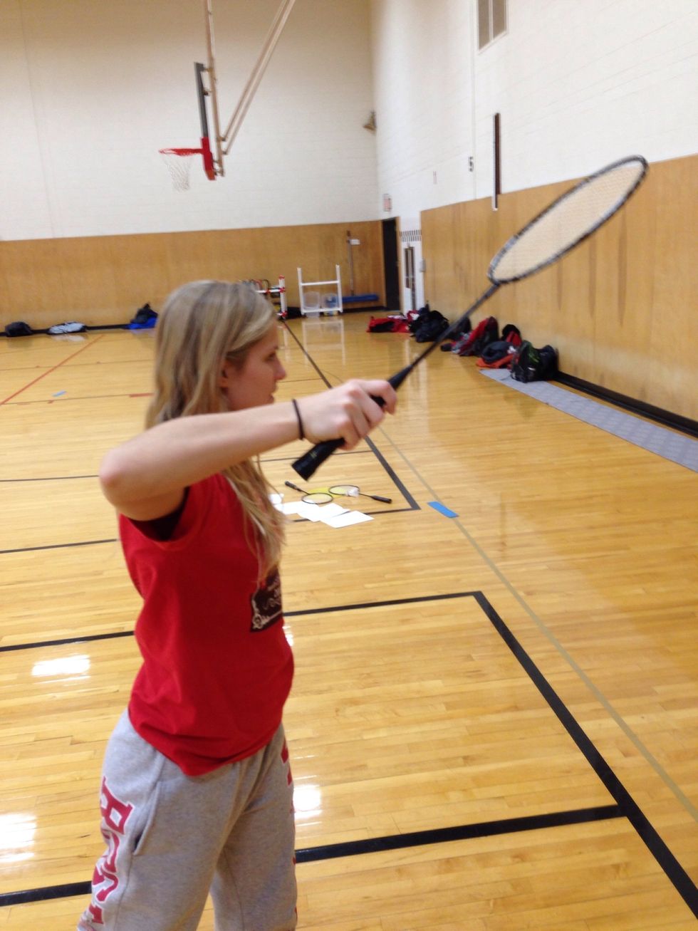 Attack with your racquet, reach high in the air and contact the shuttle with a closed racquet face in front of your racquet shoulder.