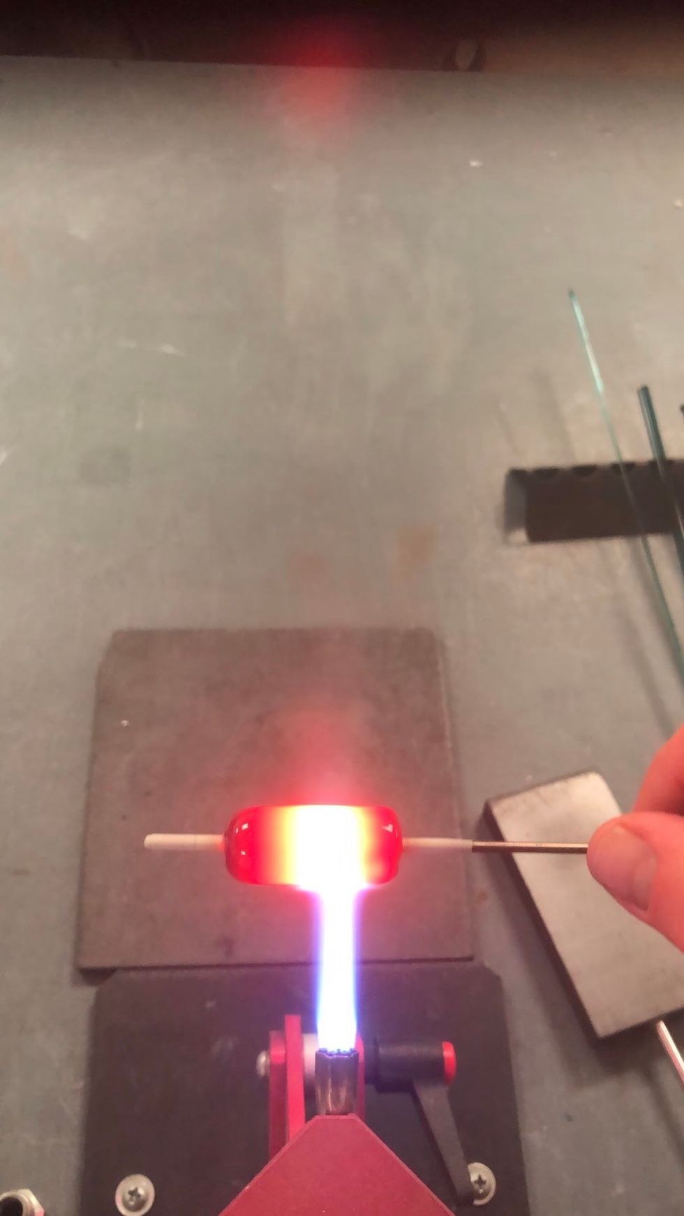 Avoiding the ends, heat the center of the bead until it smooths out.