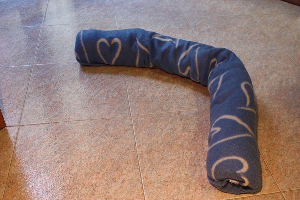 Avvolgilo nell'altra met\u00e1 della coperta. Fissala insaccando bene la coperta nelle due estremit\u00e1 del tubo.