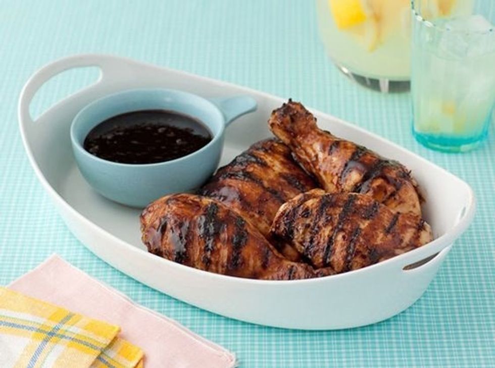 Balsamic BBQ Chicken in a white serving bowl with sauce on the side on a blue tablecloth