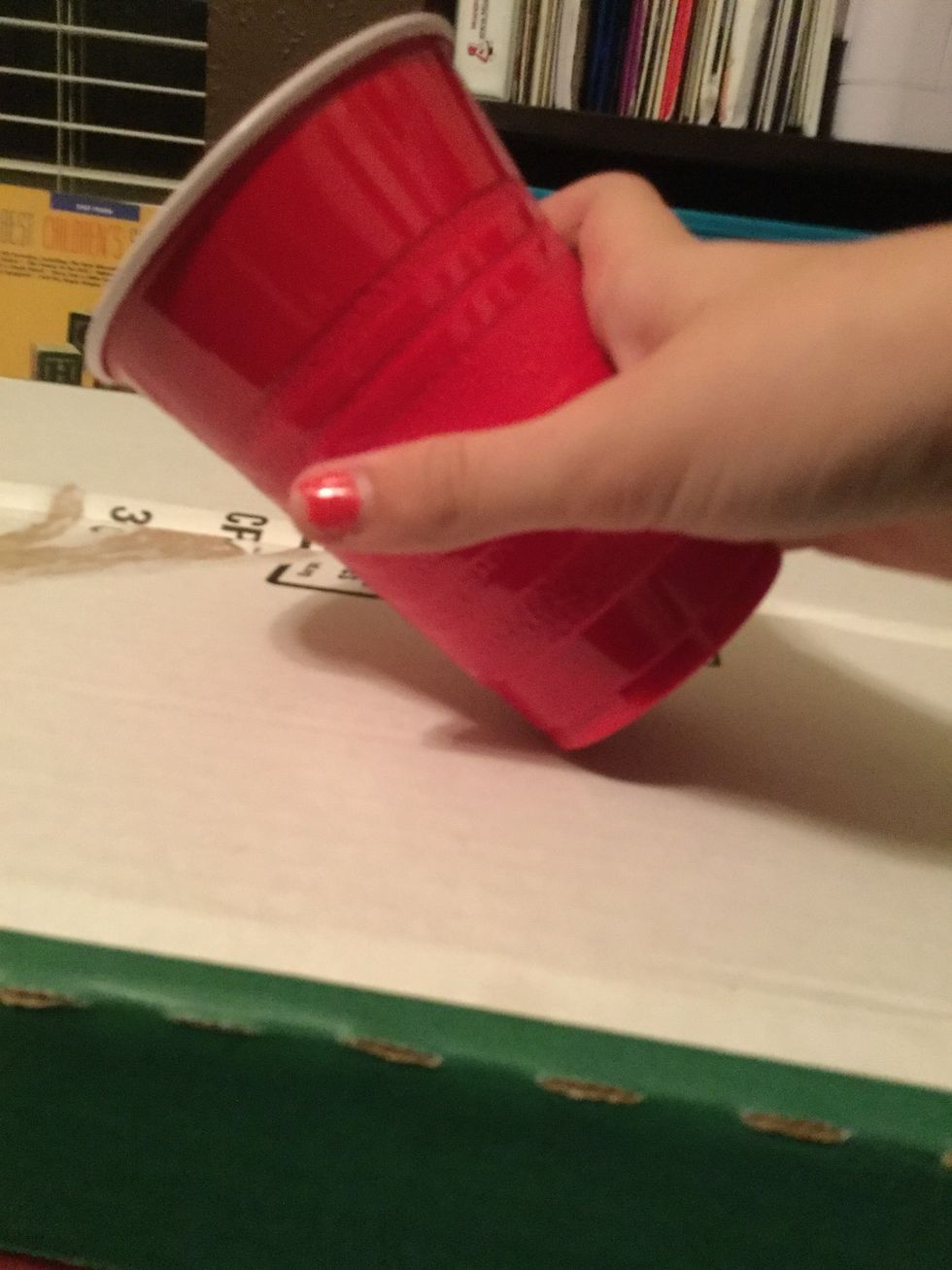 Bang the cup on the surface on its bottom left edge.