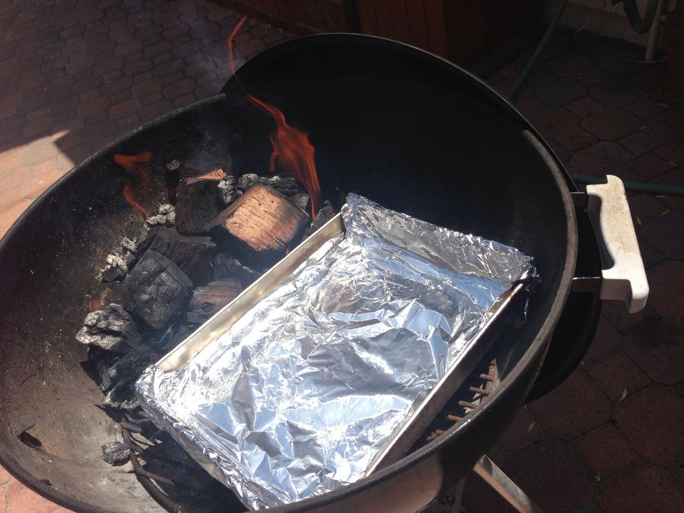 Bank the coals off to one side of the grill. Place a large, disposable aluminum pan next to the coals and fill halfway with water. This will act as a drip pan.