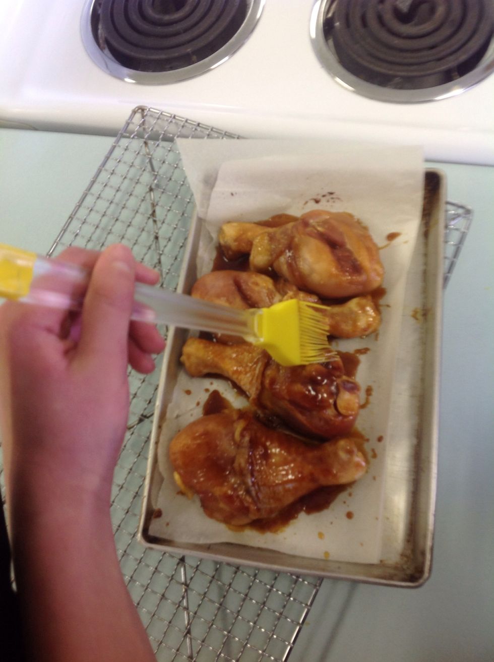 Baste the drumsticks with the marinade.