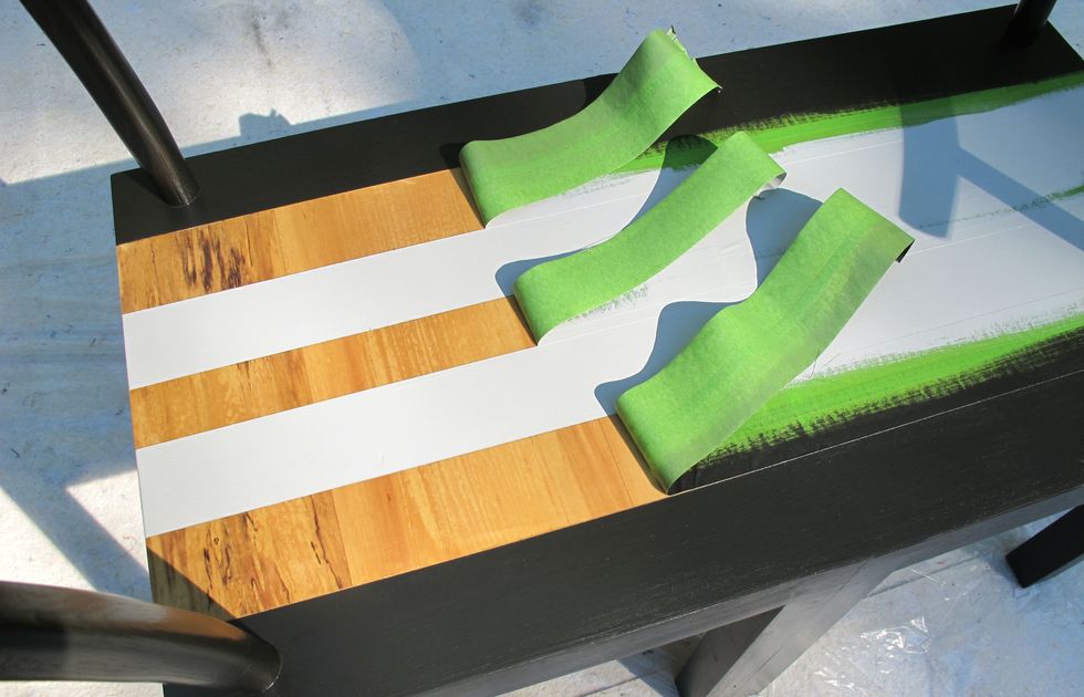Be patient! Wait for the paint to dry before peeling off the tape to reveal your first set of stripes.