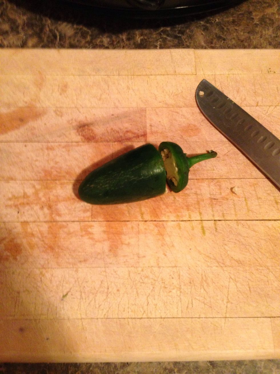 Be sure to wear gloves or wash your hands extremely well when touching the jalape\u00f1o. Cut the top off.