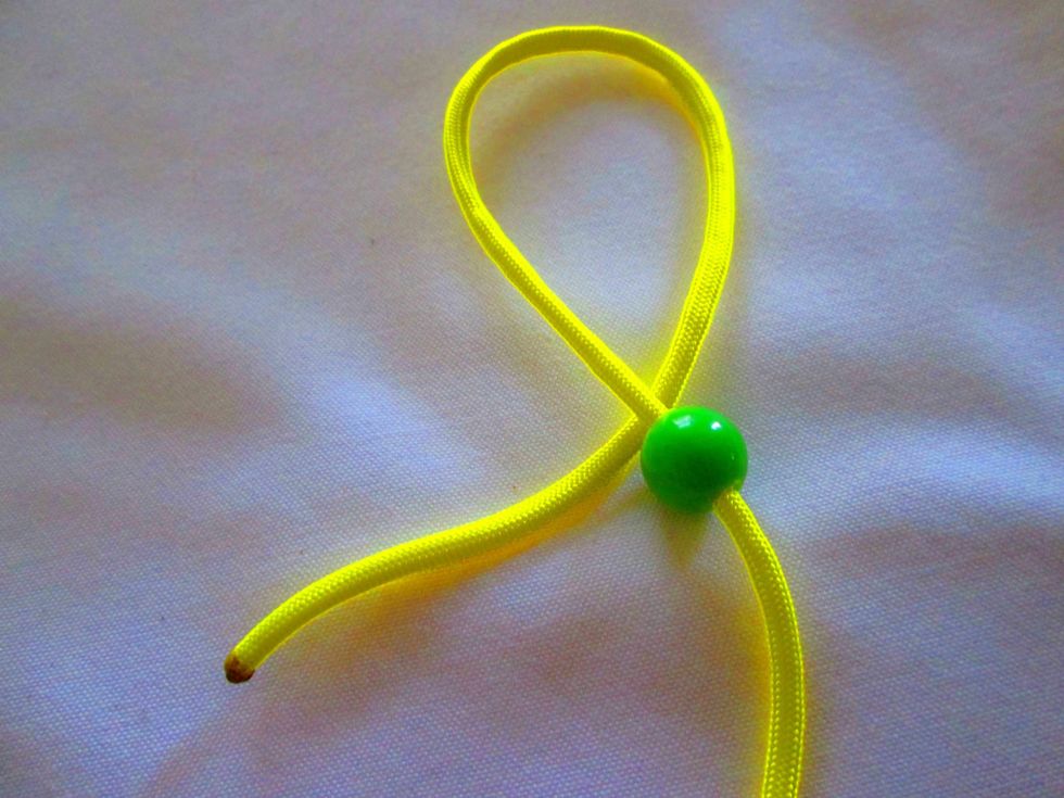 Bead It. Thread the beads onto the cord and push into the middle, out of the way.