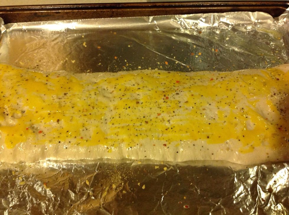 Beat egg yolk and brush on top of dough. Sprinkle with Parmesan cheese and choice of seasonings. (I used Trader Joes 21 seasoning here)