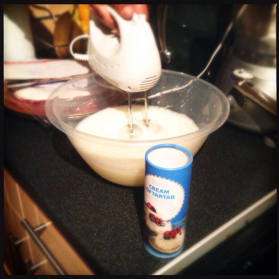 Beat the egg whites to soft peaks, adding cream of tartar after 20 seconds. Gradually add the remaining 1/4 of sugar and continue beating until whites are glossy and firm.