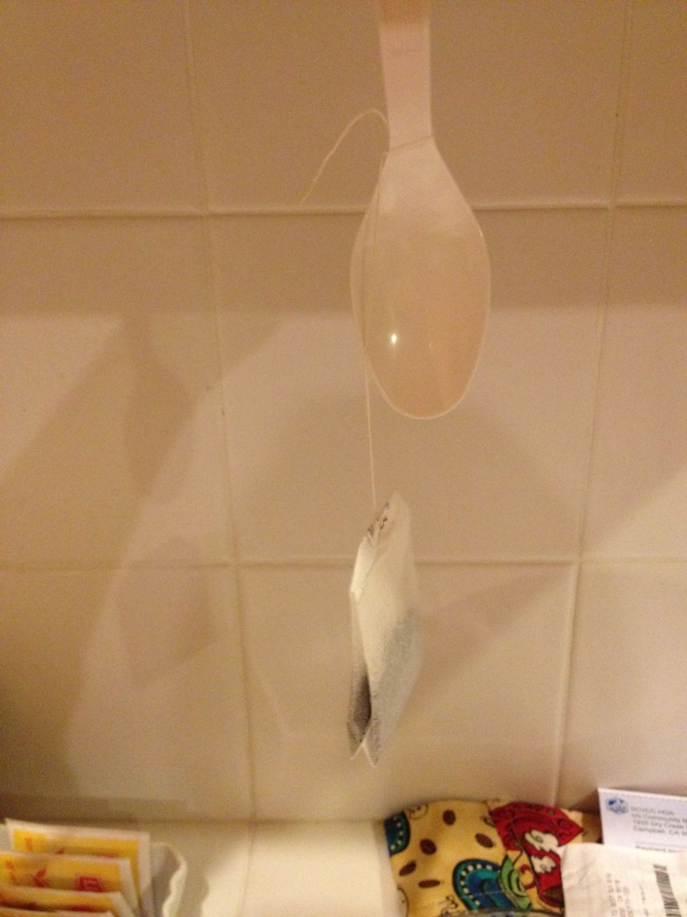 Because the knot you tied is smaller than the concave part of the spoon, the loop won't slip off.