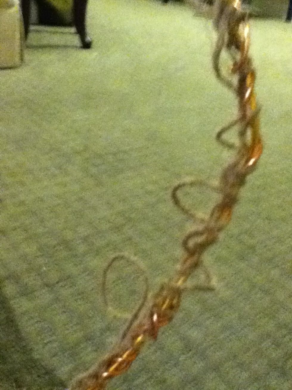 Because you didn't pull the string tight when wrapping it around the ring, you should be able to pull the weaving apart slightly, so that holes can be easily seen and twine can be stringed through.